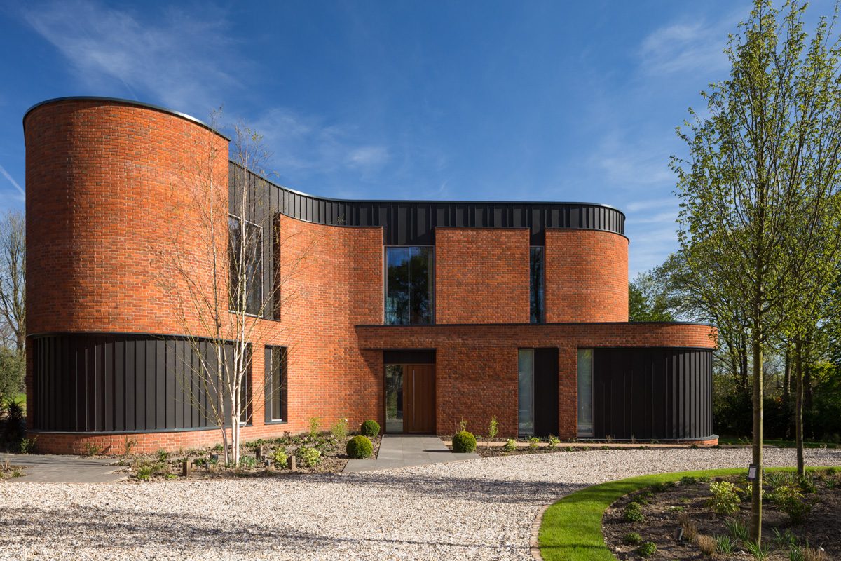 The front elevation of Incurvo — curved brick towers and zinc